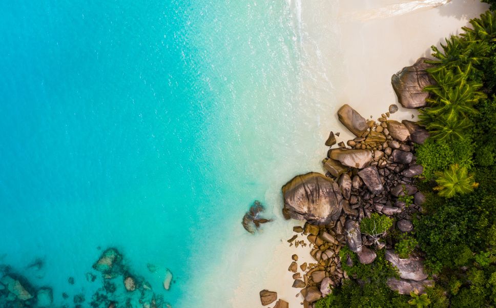 Top view of the coast line in the Seychelles with azure blue water.