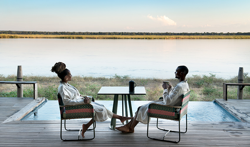 Couple relaxing by theri private plunge pool at Lolebezi Lodge, Zambia